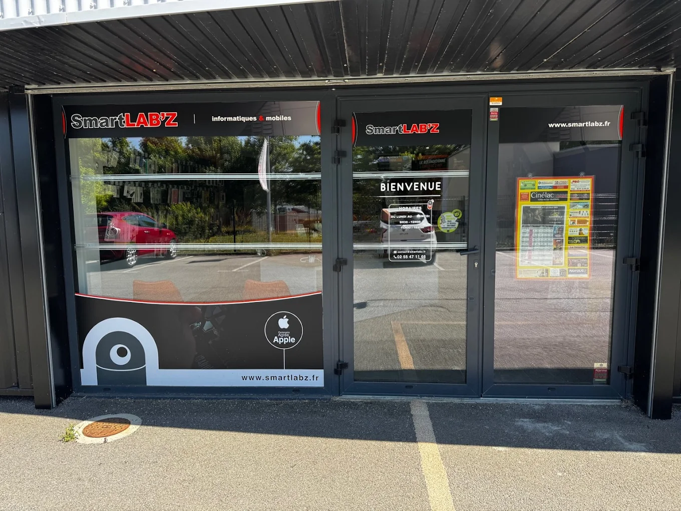 La façade de SmartLAB'Z Ploërmel, vitrine avec la mascotte et le logo Partenaire agréé Apple